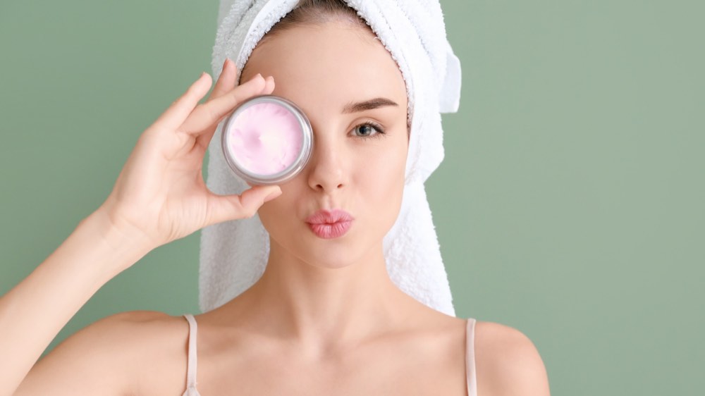A woman holding out a facial product