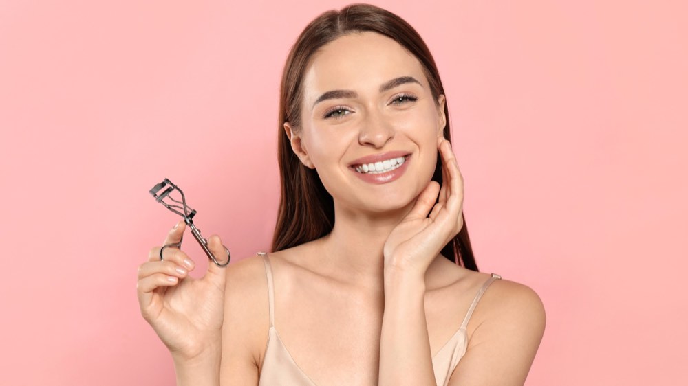 A woman holding an eyelash curler