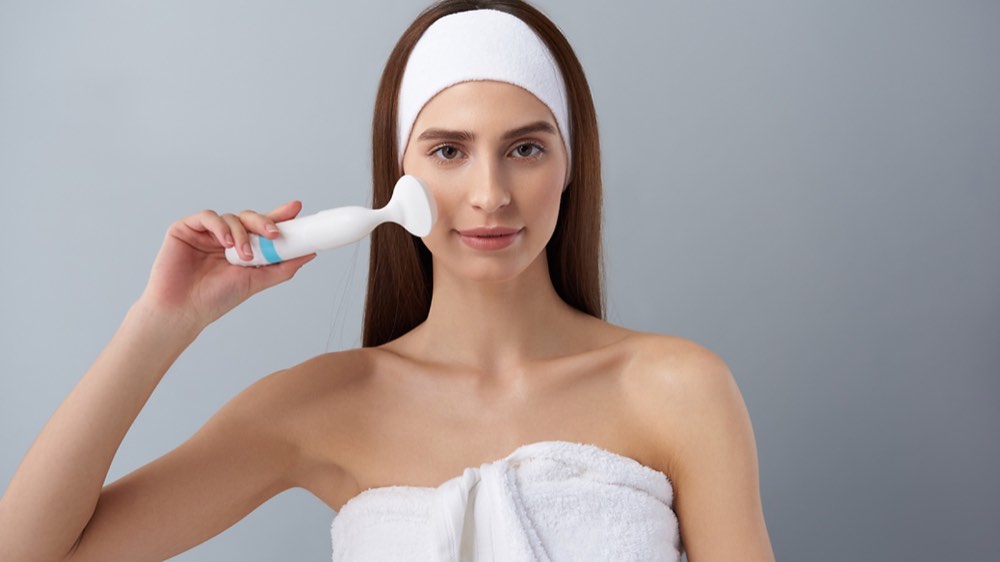 A woman holding pore cleansing brush