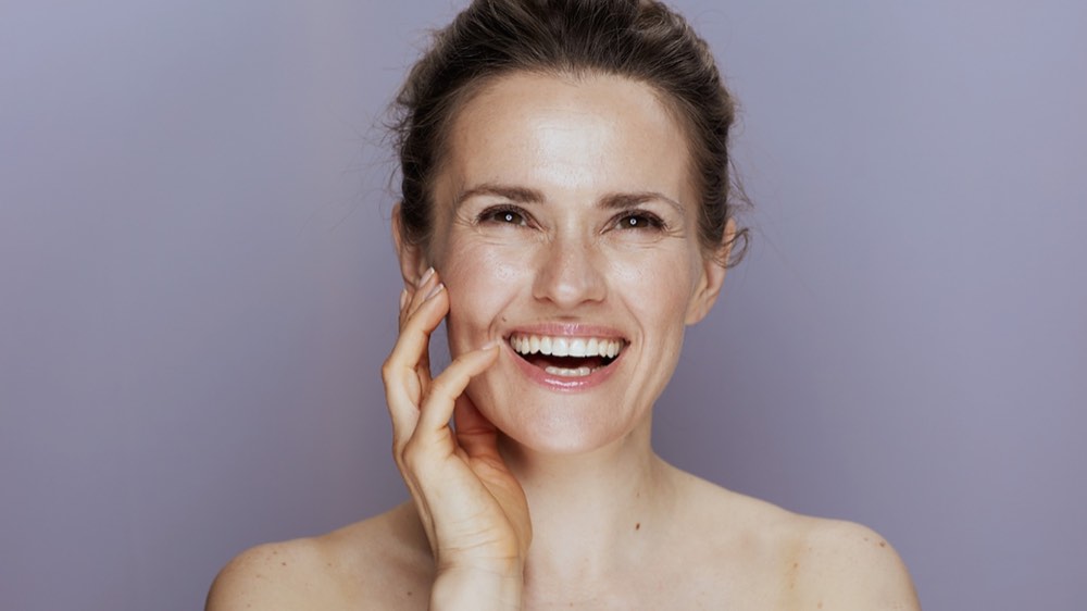 A middle aged woman caressing her face