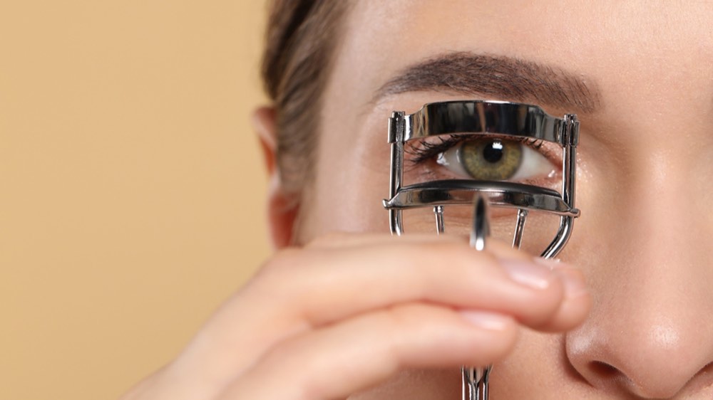 A woman holding out an eyelash curler