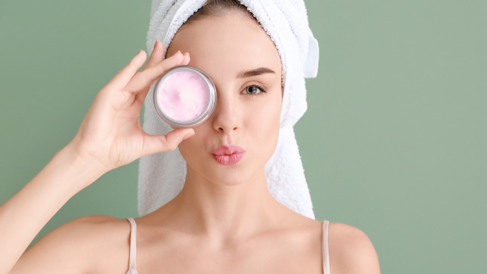 A woman holding out a facial product